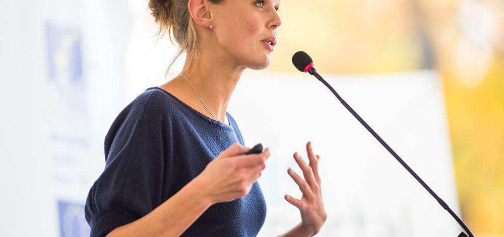 Pretty, young business woman giving a presentation in a conferen