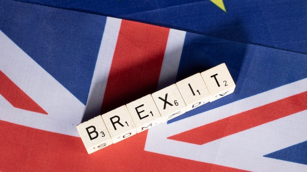 consecuencias fiscales de un brexit duro. Banderas de Unión Europea y Reino Unido superpuestas. Encima unos dados en los que está la palabra "BREXIT".