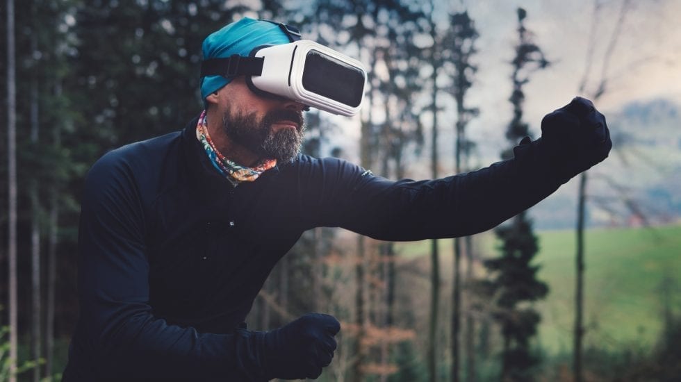 Hombre con gafas de Realidad Aumentada en medio de un bosque